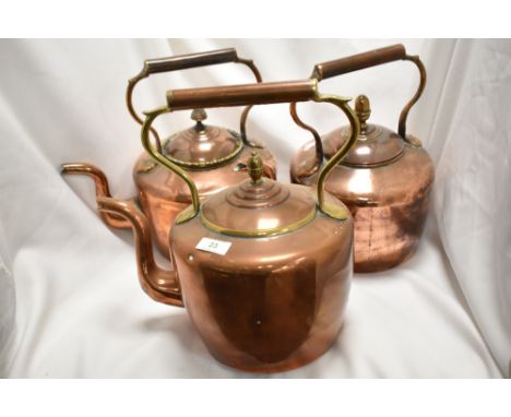 Two antique copper kettles and one vintage copper kettle.
