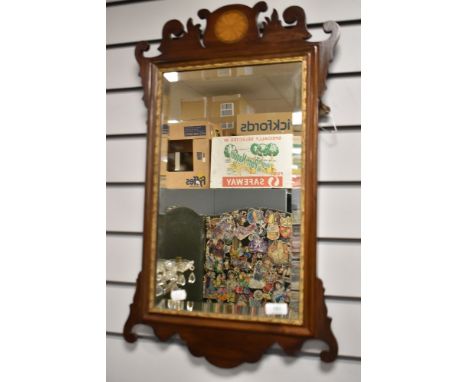 An Edwardian Chippendale style bevelled glass and fret framed mirror having inlaid frame and scrolled detailing.