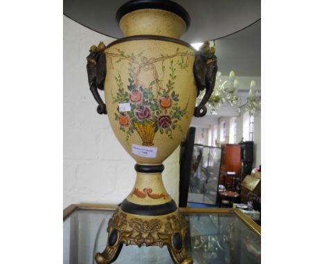 A table lamp with floral design and elephant head mounts to sides.