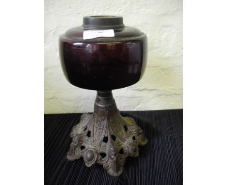 A purple glass and cast iron oil lamp base.