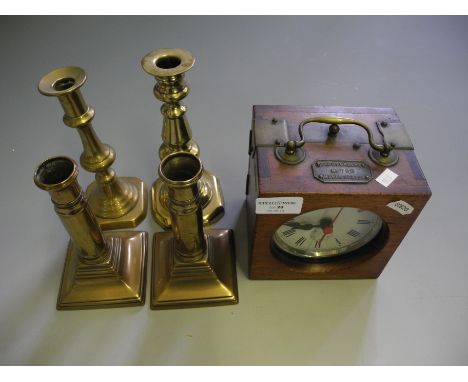A mahogany brass bound pigeon style clock together with four brass candlesticks.