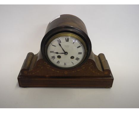 A mahogany mantle clock with inlaid decoration.