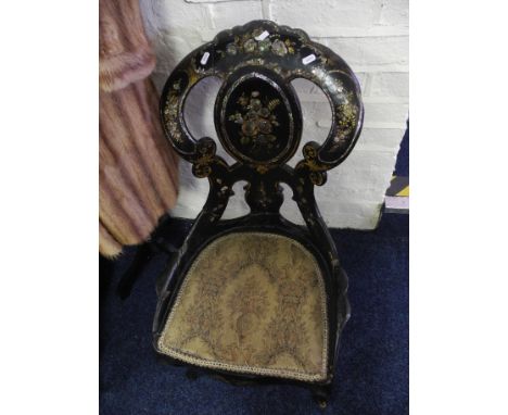 A Victorian papier-mâché chair decorated with inlaid mother of pearl.