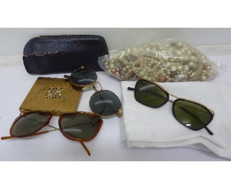 Three pairs of vintage sunglasses, a compact and beads