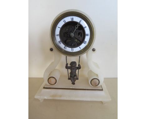 An Alabasta French clock with swinging cherub movement, 22cm tall 