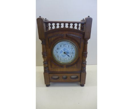 A 19th century olive wood mantle clock with white and blue enamel face, drawer to base with windows for calendar, cards not p