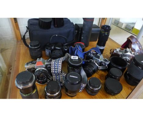 A collection of assorted camera equipment including four 35mm SLR cameras , assorted lenses and a Bell and Howell Reflex 1.8.