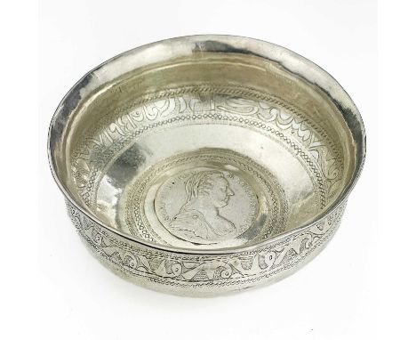 An Indian silver bowl inset with a Marie Theresa Thaler coin.  The interior with an engraved band of Islamic script, diameter