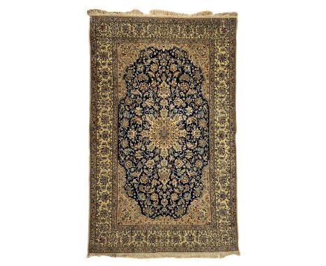 A Nain rug, Central Persia, mid-late 20th century. The indigo field with an ivory central medallion, scrolling flowering vine