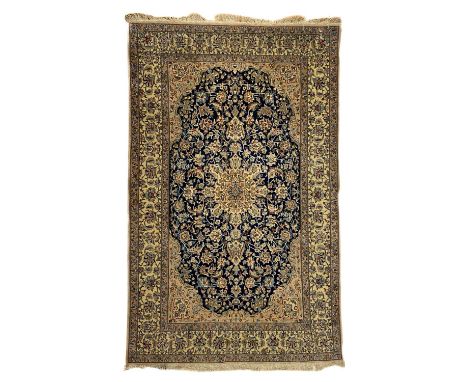 A Nain rug, Central Persia, mid-late 20th century. The indigo field with an ivory central medallion, scrolling flowering vine