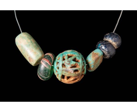 Ca. 300 BC.
A necklace comprising glass and mosaic glass beads in different shapes, colours and motifs. The central decoratio