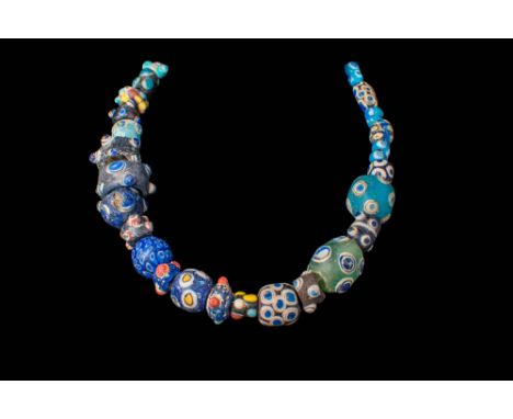 Ca. 600 - 100 BC.
A glass eye bead necklace strung with mostly spherical beads of varying sizes and d&eacute;cor scheme. Eye 