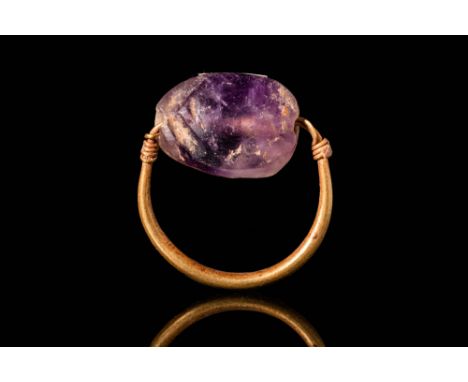 New Kingdom, Ca. 1550 - 1069 BC.A gold finger ring with polished amethyst bead in the shape of a scarab, connected to a round