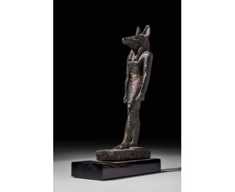 Late Period, Ca. 600 BC.
A cast leaded-bronze figure of Anubis in a classic striding pose atop an integral rectangular plinth