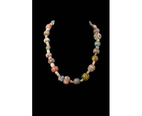 Ca. 600 - 300 BC.A necklace strung with spherical beads interspersed with shorter tubular beads. The multicoloured beads disp