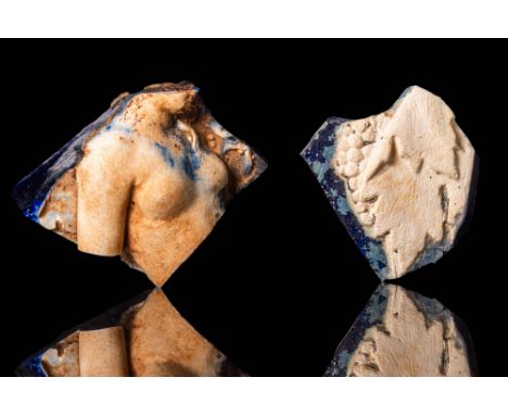 Ca. AD 50 - 200.
A pair of glass cameo fragments with a white opaque high-relief design set against a dark navy background. O