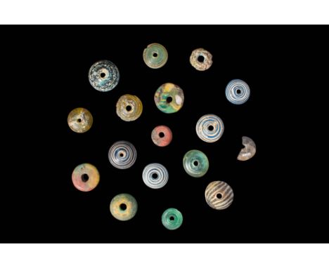 Ca. 30 BC - AD 200.
A collection of 17 glass beads, shaped as circular, flat discs with slightly domed upper sides. Each piec