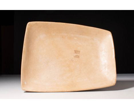 Ca. 3000 BC.
A bowl carved from hardstone featuring a rectangular body with a slightly incurving rim. The vessel has a gently