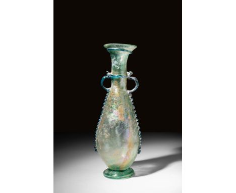 Ca. AD 300 - 500.
A pale green flask, or anphoriskos, with a pyriform body on a hollow tooled base ring. The flask has a long