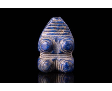 Ca. 2000 - 1000 BC.A lapis lazuli amulet in the shape of a recumbent bull, with incised striations beneath its body. The bull