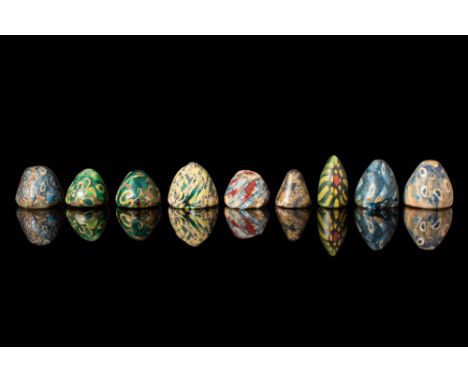 Ca. 30 BC - AD 200.
A set of nine cone-shaped mosaic glass inlays featuring intricate designs with bright canes set against d