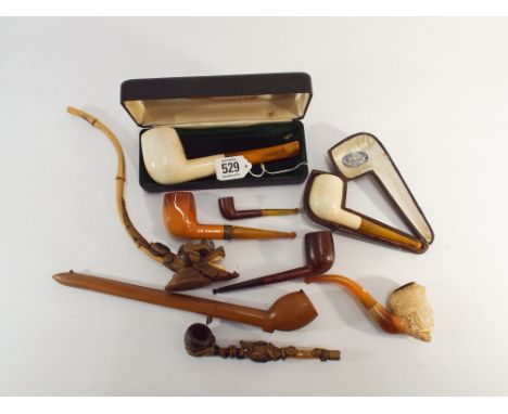 A collection of 19th century and later pipes and pipe cases in meerschaum with amber stems etc