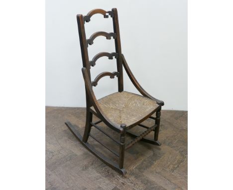 A ladder back rocking chair with rush seat