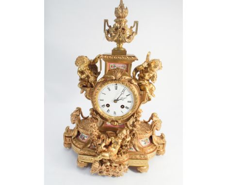 19th century striking French mantel clock in gilded ormolu case decorated with cherubs and pink floral Sevres style panels   