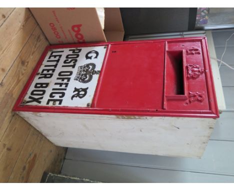 A George V/VI red wall mounted letter box, with later painted timber box, 69cm x 35cm and a brass plaque with twin slots for 