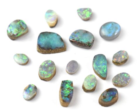 Approximately sixteen polished opal segments of various shapes and sizes, the predominant colours being greens and blues. CON