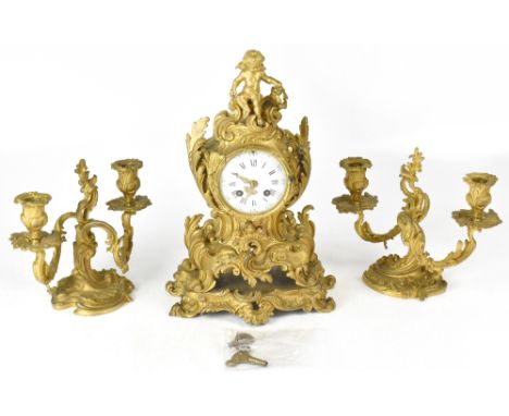 A late 19th French century gilt metal clock garniture, the circular white enamelled dial set with Roman numerals within an el
