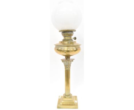 An Edwardian brass oil lamp with brass oil reserve, Classical reeded column support to stepped square base, with opaque white