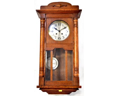 An oak cased regulator WALL clock, the silvered circular dial set with Arabic numerals and key winding holes, height 75cm, wi