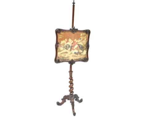 A 19th century mahogany pole screen with turned finial to the top, the screen with scroll and acanthus leaf decoration, tapes