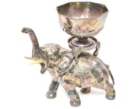 A late 19th/early 20th century Oriental hollow cast electroplated elephant shown wearing headdress with back covers, trunk up
