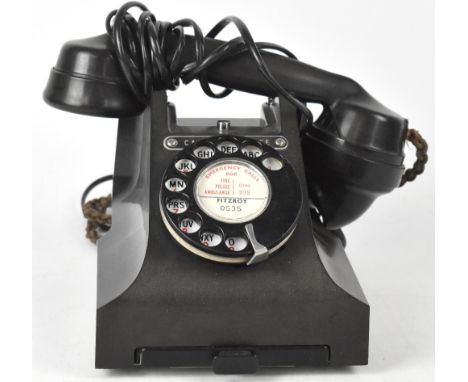 A vintage black bodied Bakelite telephone with drawer to base and bearing plaque inscribed, 'Call Exchange'. CONDITION REPORT