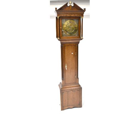 An early 19th century oak longcase clock, broken swan neck pediment with brass decoration to the centre, carved frieze above 