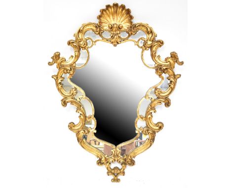 A large modern wall mirror in the Chippendale style, with large open scalloped shell to the top and a flowing border of C-scr