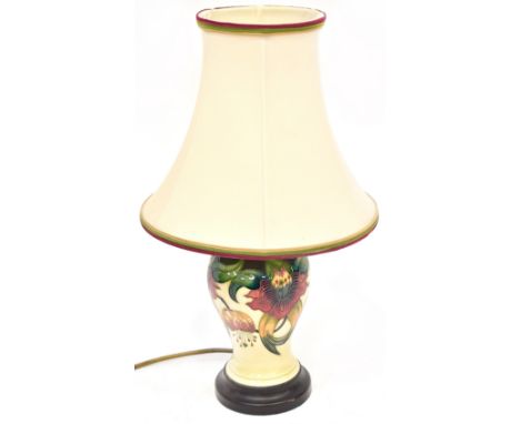 MOORCOFT; an 'Anna Lily' pattern pottery lamp with tube lined decoration, of baluster shape on wooden plinth, with matching s