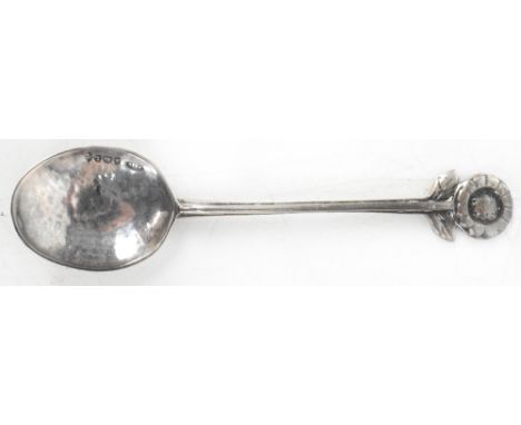 An Arts &amp; Crafts hammered silver spoon, the hallmarked hammered bowl with straight handle leading to flower finial, Winif