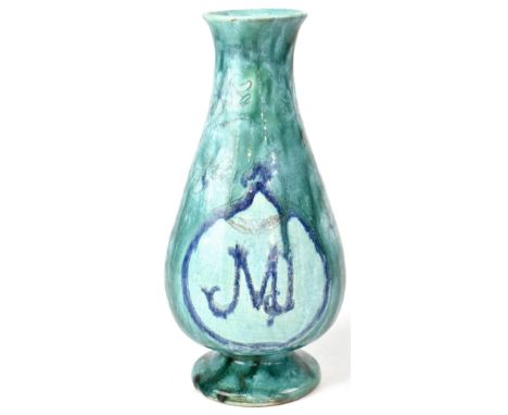 DELLA ROBBIA; a vase of baluster form with incised and highlighted magnolia decoration under a streaked green glaze with blue