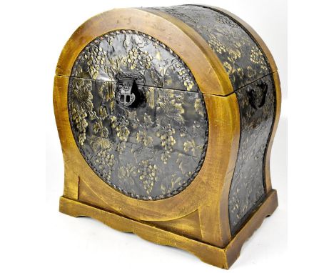A wooden Polyphon record box of domed form, impressed with Oriental-style metal panels of grapes and vines, with twin carryin