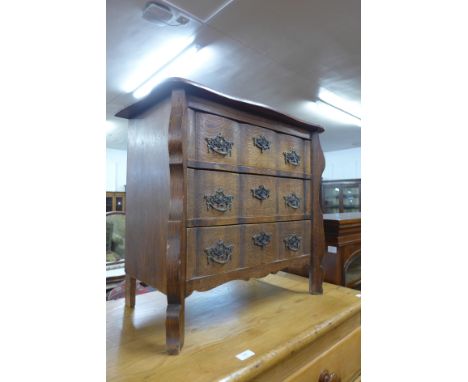 A French oak bombe shaped petit commode 