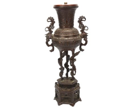 A Chinese bronze incense burner converted to a lamp, with cast scrolled handles, raised on hexagonal bronze stand, height 41c