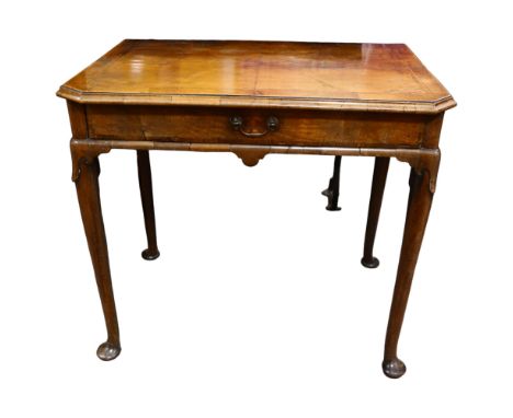 George II Period walnut side table, the feather banded and quarter veneered canted top above a single frieze drawer, with tur