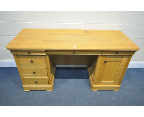 A SOLID LIGHT OAK DESK, with an arrangement of six soft open and close drawers and a single cupboard door (condition:-surface