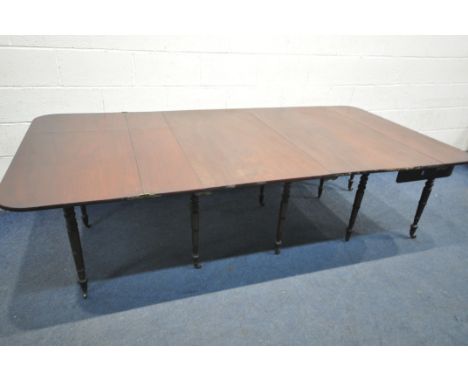 A REGENCY MAHOGANY CONCERTINA ACTION EXTENDING DINING TABLE, with two sized additional leaves, on ten turned legs with brass 