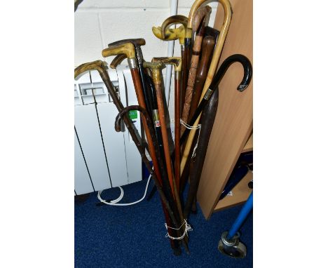 TWO BUNDLES OF ASSORTED WALKING STICKS, CANES AND A CLUB, MOSTLY 20TH CENTURY, includes one with a silver mount and a horse m