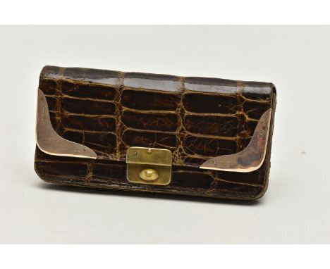 AN EARLY 20TH CENTURY CROCODILE SKIN PURSE, mounted with two 9ct rose gold hard wear corners to the purse top, each piece hal