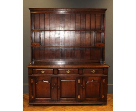 A Titchmarsh and Goodwin oak tall dresser, the rack with open shelves and two spice drawers, the base fitted three frieze dra